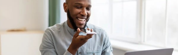 african-businessman-with-smartphone-using-voice-assistant-app-or-loudspeaker