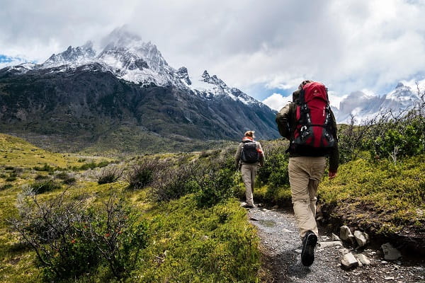people-hiking-along-path-with-mountains-in-the-background-1